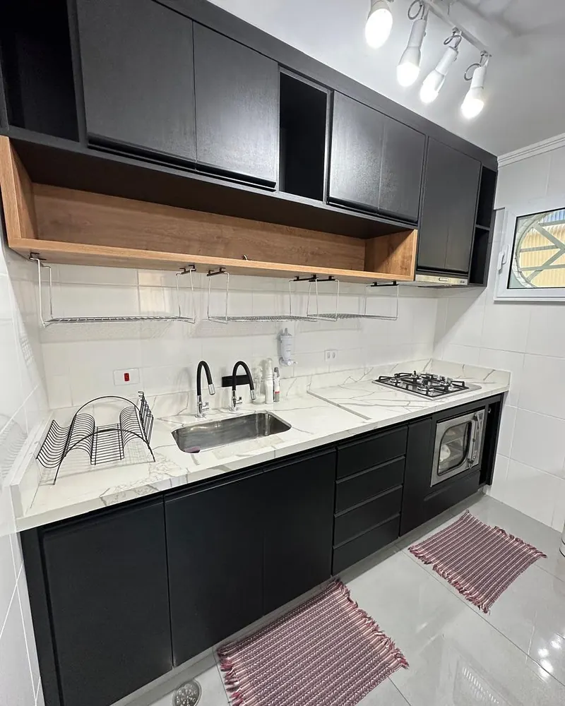 Cozinha preta com nicho amadeirado, projeto da A Fábrica