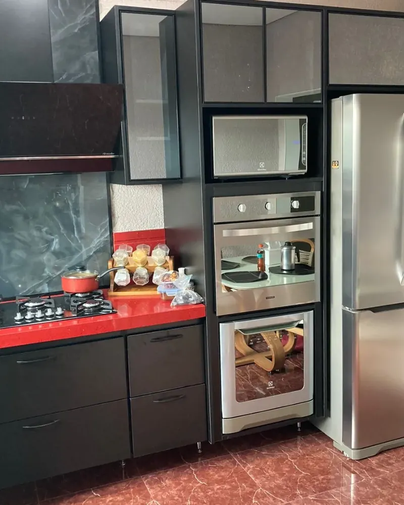 Cozinha preta com torre de fornos, projeto da A Fábrica