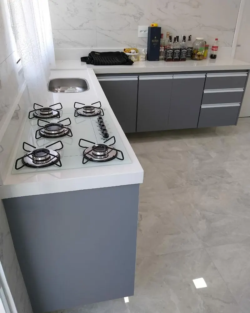 Cozinha cinza com bancada branca, projeto da A Fábrica