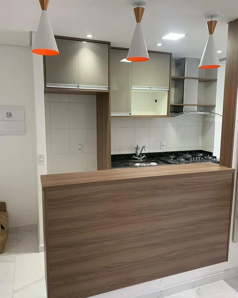 Cozinha com bar e pendentes, projeto da A Fábrica